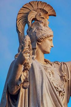 the statue is wearing an elaborate headdress and holding a bird in his hand