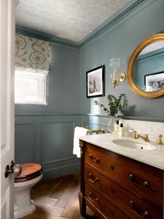 a bathroom with blue walls and wood floors