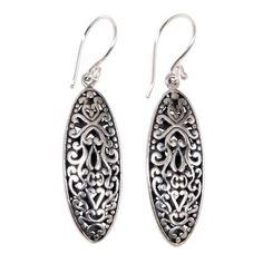 Inspired by traditional Balinese designs Komang Suastra hand crafts this lovely pair of earrings. These unique oval shpaed sterling silver earrings feature an intricately engraved floral motif accented by an oxidized finish. Ornate Oval Pierced Earrings, Traditional Oval Filigree Earrings, Oval Earrings With Intricate Design For Anniversary, Traditional Engraved Teardrop Earrings, Oval Filigree Earrings, Ornate Oval Sterling Silver Earrings, Silver Oval Earrings With Intricate Design, Ornate Oval Earrings As Gift, Traditional Sterling Silver Engraved Earrings