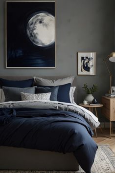 a bed with blue and grey comforters in a bedroom next to a painting on the wall