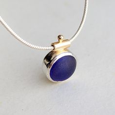 This captivating deep cobalt blue sea glass necklace from Booblinka Jewellery’s Allure Collection is a one-of-a-kind treasure that reflects the mesmerizing depths of the Cornish coast. Hand-shaped and set in a harmonious mix of sterling silver and 9 carat gold, the stunning sea glass pendant showcases the timeless allure of the ocean. The cobalt blue sea glass, approximately 10mm in diameter and 15mm in height, mirrors the vibrant hues and textures of the Atlantic waves. Suspended from an 18-inc Elegant Blue Sea Glass Jewelry, Blue Sea Glass Necklaces For Jewelry Making, Blue Round Recycled Glass Jewelry, Blue Recycled Glass Round Jewelry, Blue Recycled Glass Pendant Necklace, Sea Glass Mirror, Blue Sea Glass Necklace, Cornish Coast, Sea Glass Pendant