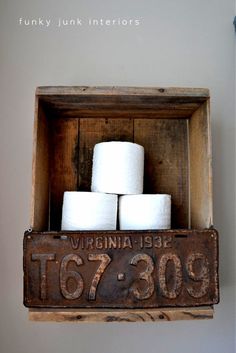 a wooden box with four rolls of toilet paper in it and a sign that says virginia