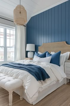 a bedroom with blue walls and white bedding