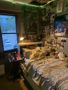 an unmade bed in a dorm room with posters on the wall