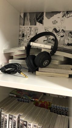 headphones are sitting on top of books in a book store, with other books behind them