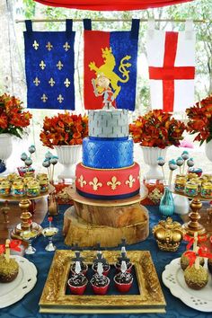 a table topped with lots of cakes and desserts covered in frosting next to flags