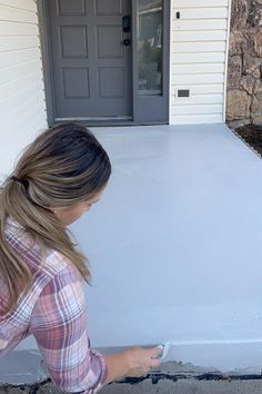 a woman painting the side of a house