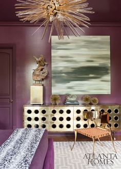 a bedroom with purple walls and furniture in the room, including a chandelier