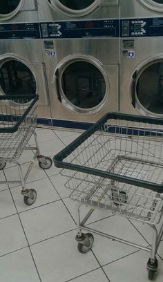 two shopping carts sitting next to each other in front of washers