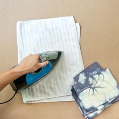 a person ironing fabric on top of a piece of cloth next to an iron