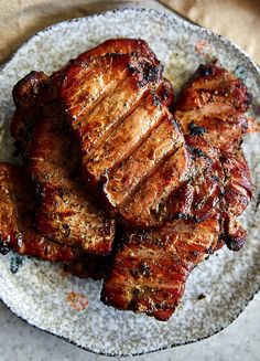 grilled meat on a plate sitting on top of a table