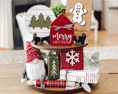 a christmas decoration on a table with books and decorations in the shape of santa's house