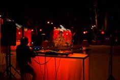 a dj set up in the middle of a dark park at night with red lights