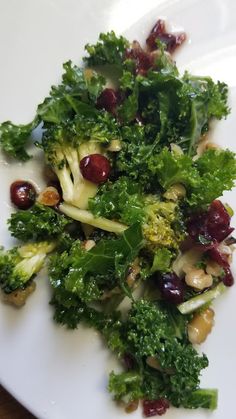 a white plate topped with broccoli and raisins on top of it