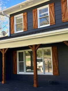 a house with wooden shutters on the front and side of it's windows