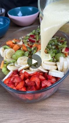 someone pouring dressing into a bowl of fruit salad