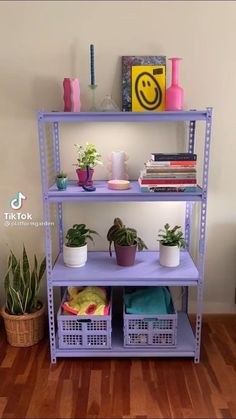 a purple shelf filled with potted plants on top of a hard wood floor