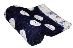 a blue and white polka dot knitted blanket on a white background with black dots