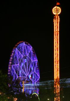 the ferris wheel is lit up at night