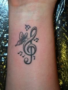 a wrist tattoo with musical notes and a butterfly