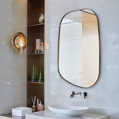 a bathroom with a sink, mirror and shelves