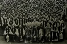 a large group of people with masks on their faces standing in front of each other