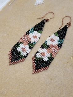 a pair of beaded earrings with flowers on them