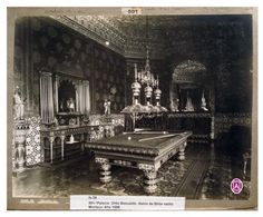 an ornately decorated room with chandeliers, tables and chairs in black and white