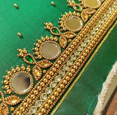 a green cloth with gold beading on it