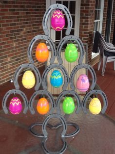 there is a sculpture made out of plastic balls on the table and in front of a brick building