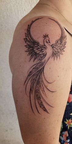 a woman's shoulder with a tattoo design on the back of her left arm