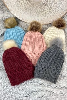 four knitted hats with pom - poms on top and the words super bulky written