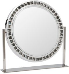 a round mirror sitting on top of a metal stand in front of a white background