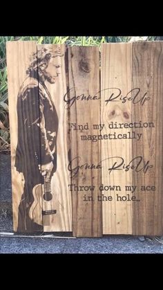 a wooden sign with an image of a man holding a guitar and words on it