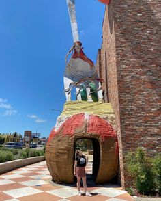 a woman standing in front of a giant statue