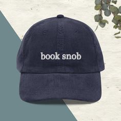 Indulge your bookish side with our Embroidered Corduroy "Book Snob" Dad Hat! Crafted from premium corduroy, this hat blends comfort and style seamlessly. The meticulously embroidered "Book Snob" design adds a touch of sophistication to your look, making it perfect for book club meetings or casual outings. This dad hat isn't just an accessory; it's a declaration of your love for literature. Stand out with its elegant script and eye-catching detail, sparking conversations wherever you go. Ideal fo Corduroy Book, Book Hat, Embroidered Book, Embroidered Corduroy, Book Club Meeting, Corduroy Hat, Dad Hat, Metal Buckles, Trucker Cap