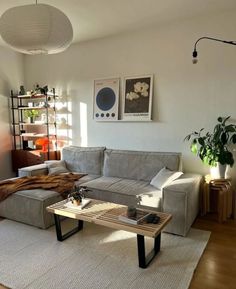 a living room filled with furniture and a wooden table on top of a hard wood floor