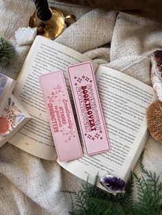 two pink bookmarks sitting on top of an open book