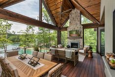 an outdoor living area with wood flooring and large windows on the side of it