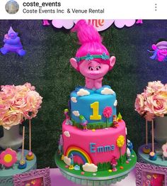 there is a pink troll cake on the table