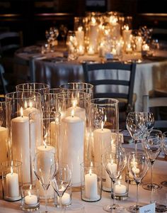 a table topped with lots of white candles