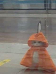 an orange umbrella sitting on top of a sidewalk