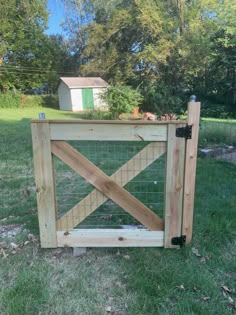 a wooden gate in the middle of a field