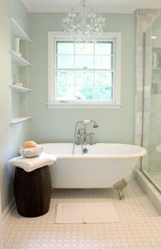 a white bath tub sitting in a bathroom next to a window