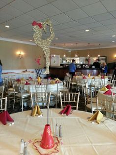 tables and chairs are set up for an event with white tablecloths, red napkins, and decorations