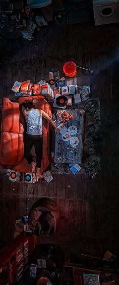 a man standing on top of a couch surrounded by clutter and junk in a dark room