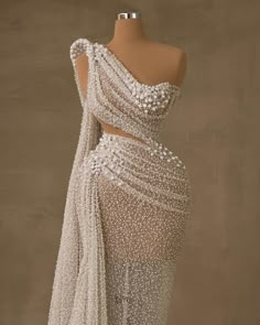 the back of a white dress with pearls on it