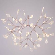 a chandelier with lights hanging from it's branches in the shape of a snowflake