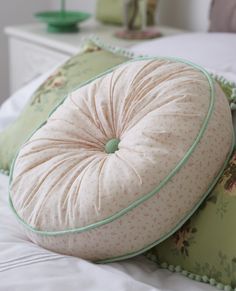 two pillows sitting on top of a bed next to each other in front of a nightstand