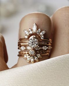 a close up of a person's hand with rings on their fingers and diamond ring